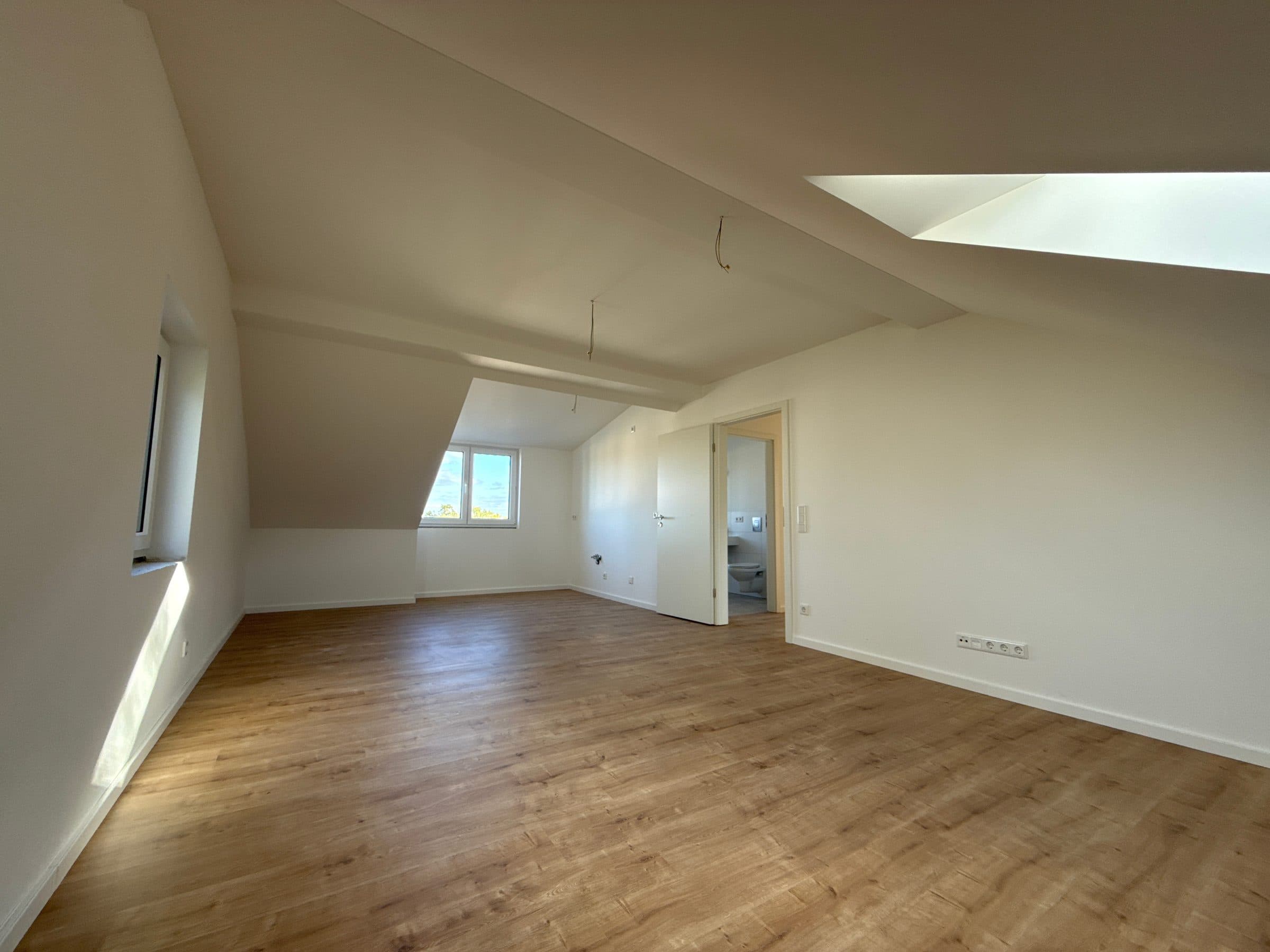 Heller Wohnbereich unter der Dachschräge mit Dachfenster, Gaubenfenster und Holzboden