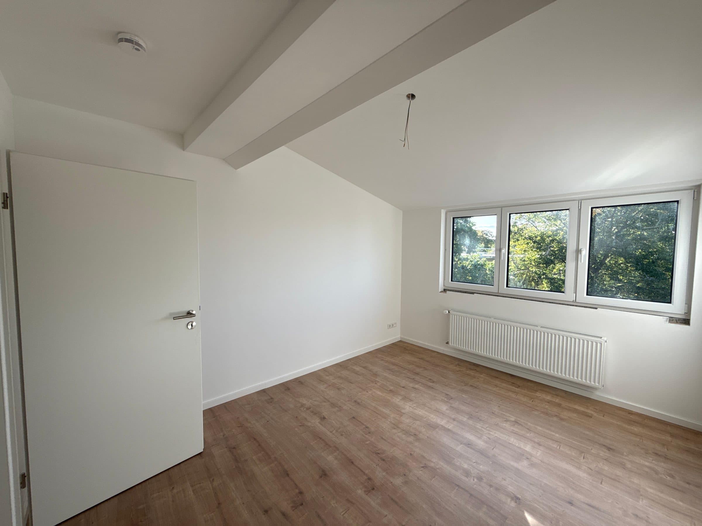 Schlafzimmer mit Dreifachfenster, Blick in Baumkronen