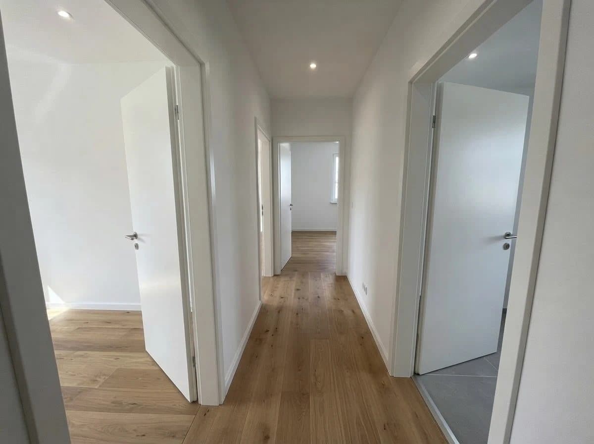 Wohnung 1: Diele mit Holzboden und offenen Türen zu den Zimmern